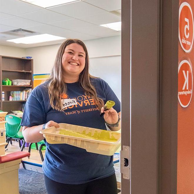 Student painting a classroom wall for day of service